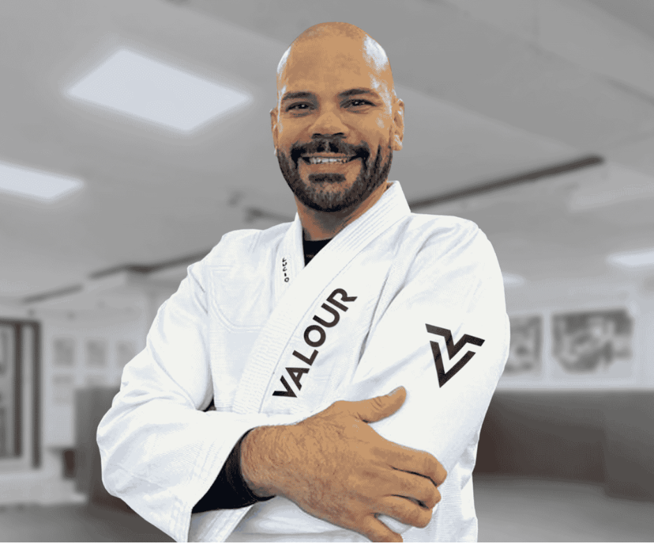 Professor Lucio, black belt BJJ instructor at Valour Jiu-Jitsu, smiling while standing inside the academy.